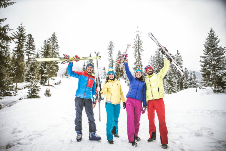 Group of friends with ski on winter holidays - Skiers having fun on the snow